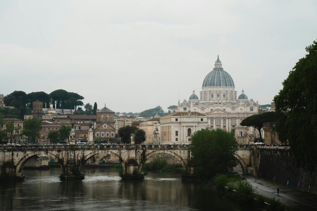 Scenic view of Rome featuring St. Peter's Basilica and the Tiber River, capturing historic Italian architecture.